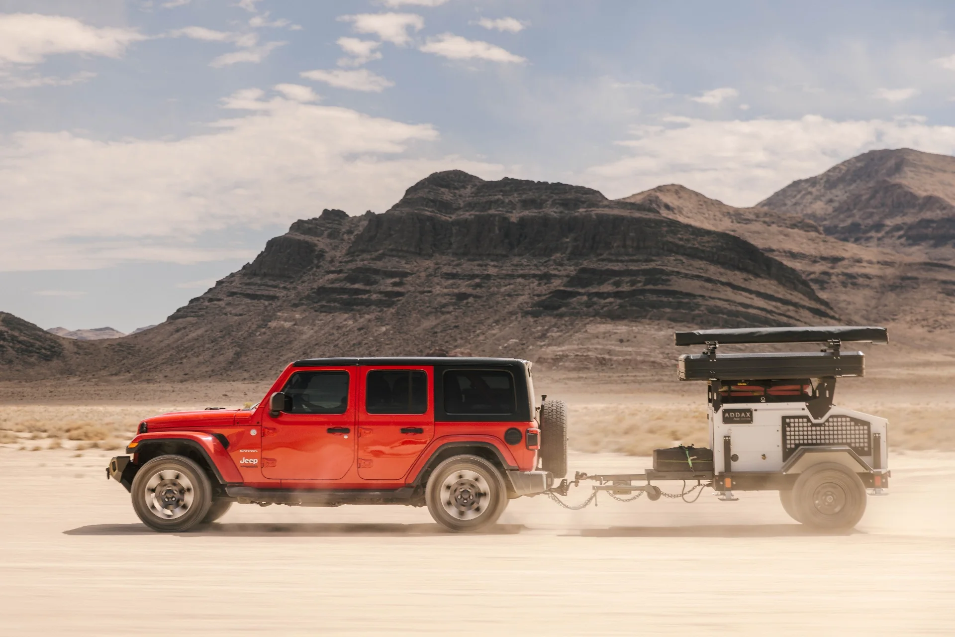 ADDAX overland trailer parked on a rocky trail behind a Jeep